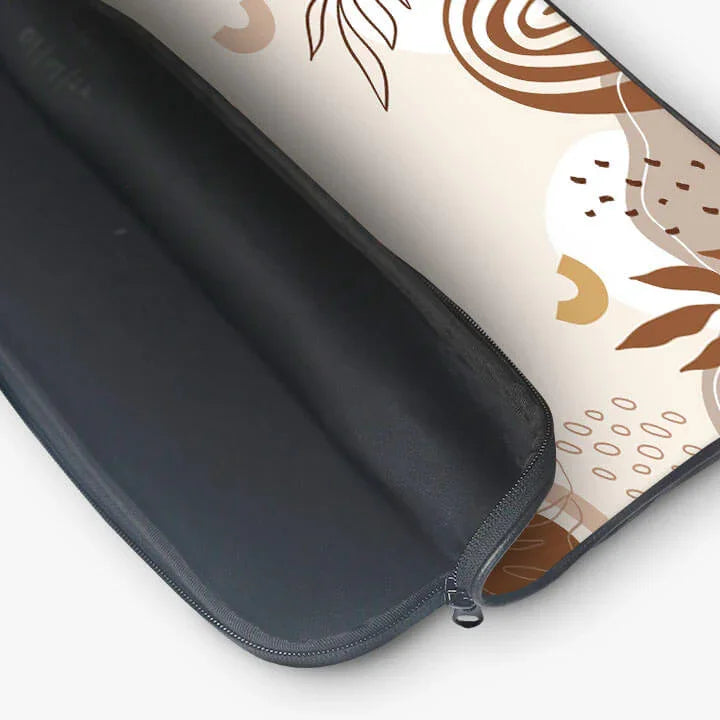 Open 13-inch laptop sleeve with abstract beige and brown leaf and swirl design, zip pouch