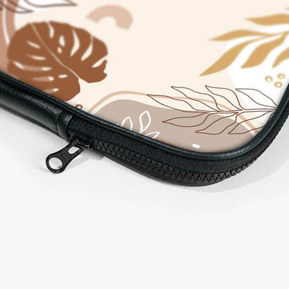 Close-up of 13-inch laptop sleeve with zipper and beige botanical leaf design