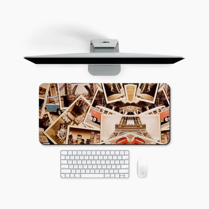 Large desk mat with vintage travel postcard collage, under monitor, keyboard, and mouse