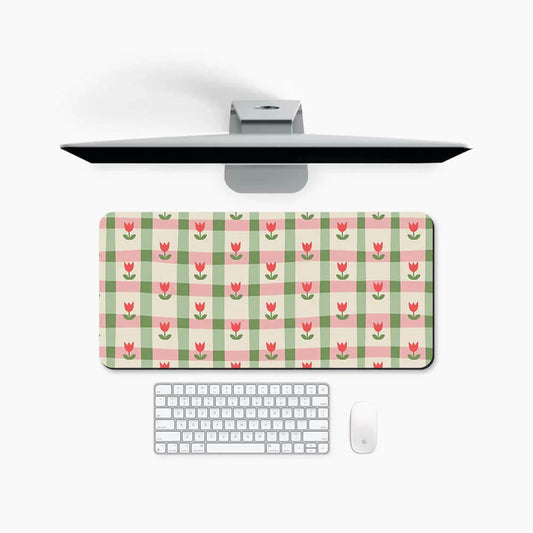 Large desk mat with pink floral and green checkered pattern, placed under monitor and keyboard