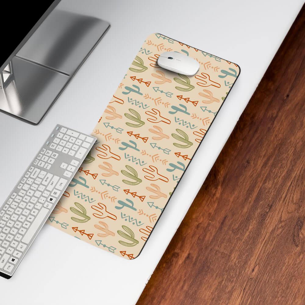 Desk mat with colorful cactus and arrow pattern on modern office desk beside keyboard and mouse