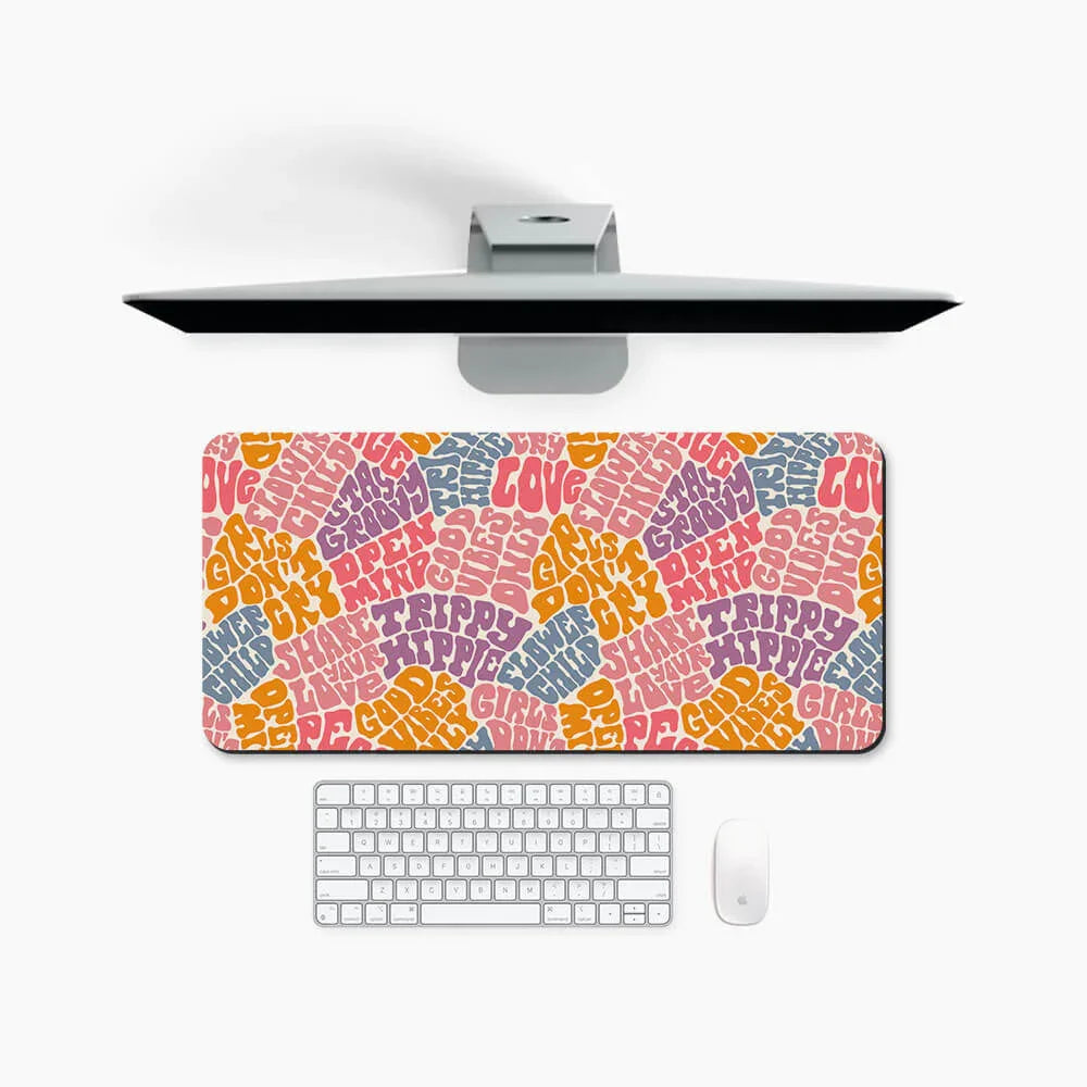 Colorful desk mat with retro font phrases, placed on a white workspace with keyboard and monitor