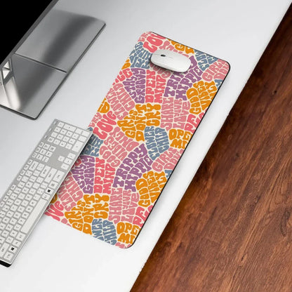 Colorful desk mat with psychedelic text design under keyboard and mouse on white desk