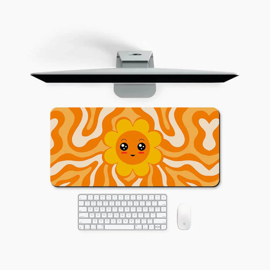 Desk mat with cute sun face and orange wavy pattern, keyboard and mouse on white desk