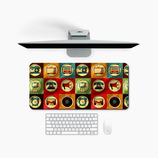 Colorful retro desk mat with vintage technology icons, under a monitor, keyboard, and mouse
