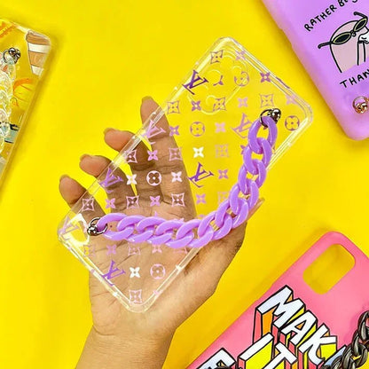 Clear phone case with purple chain and pattern, held in hand on yellow background