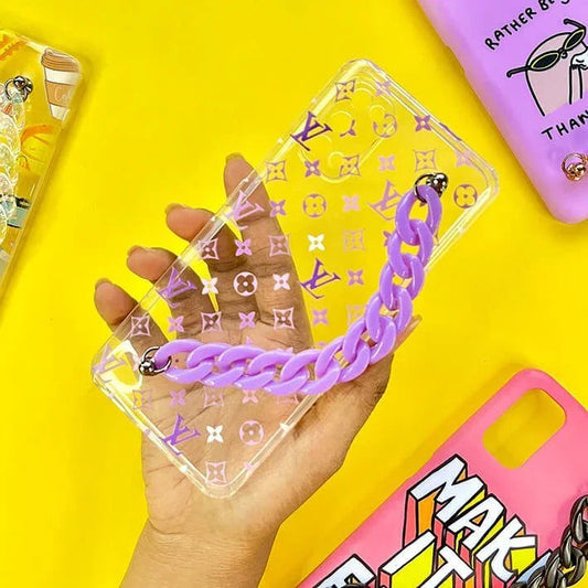 Clear phone case with purple chain and pattern, held in hand on yellow background