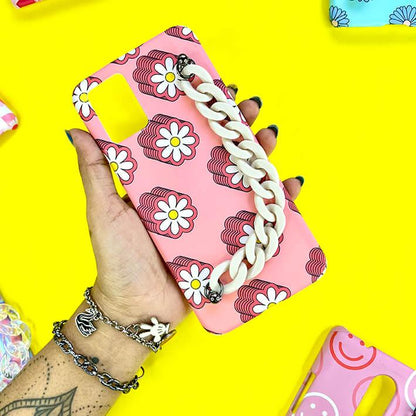 Pink phone case with white daisy flower print and chunky cream chain handle, held in hand