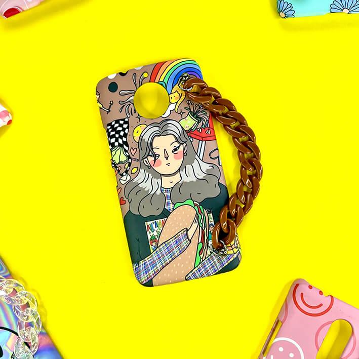Colorful cartoon girl phone case with brown chain handle on yellow background.