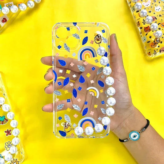Clear phone case with blue leaves, rainbow design, and pearl chain held on yellow background