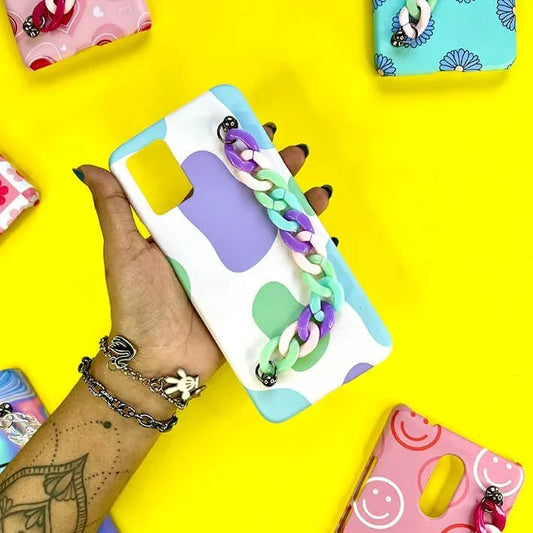 Hand holding pastel abstract chain phone case, surrounded by colorful designer covers