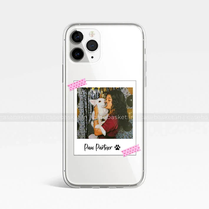 Clear phone case with polaroid design showing woman hugging white dog, 'Paw Partner' text.