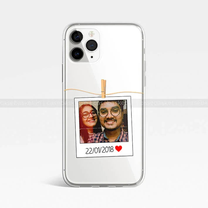 Transparent phone case with customized polaroid photo print and date, clear background.
