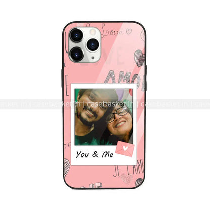 Pink phone case with love motifs and a polaroid-style photo labeled You & Me