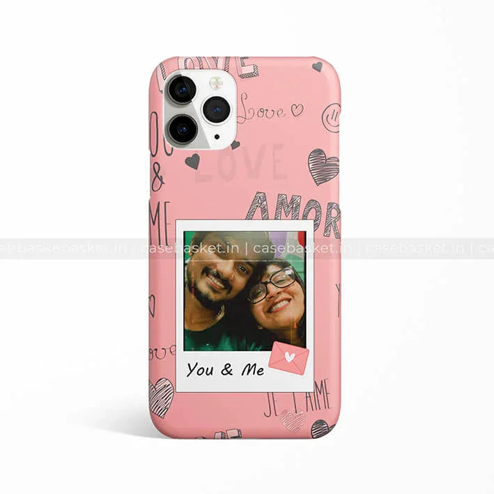 Pink love-themed smartphone case with polaroid-style couple photo and heart doodles