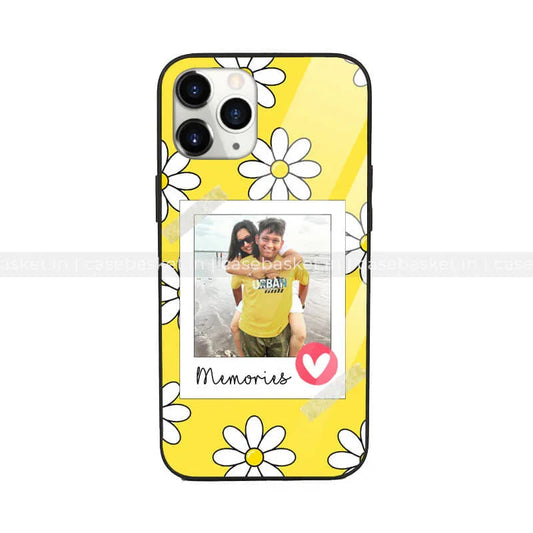 Yellow phone case with white daisy pattern and polaroid-style photo labeled 'Memories'.